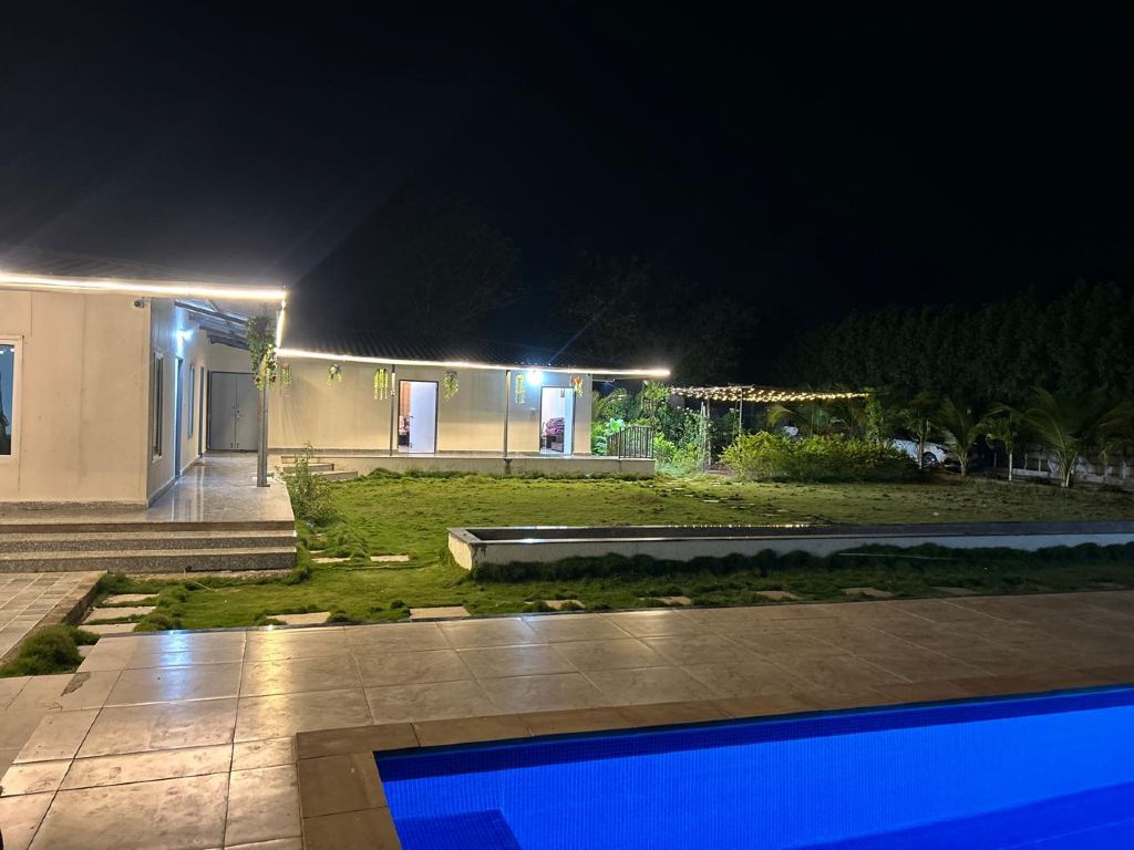 Pool lit up at night at Eshwara Greens Farm, Aziz Nagar, Moinabad